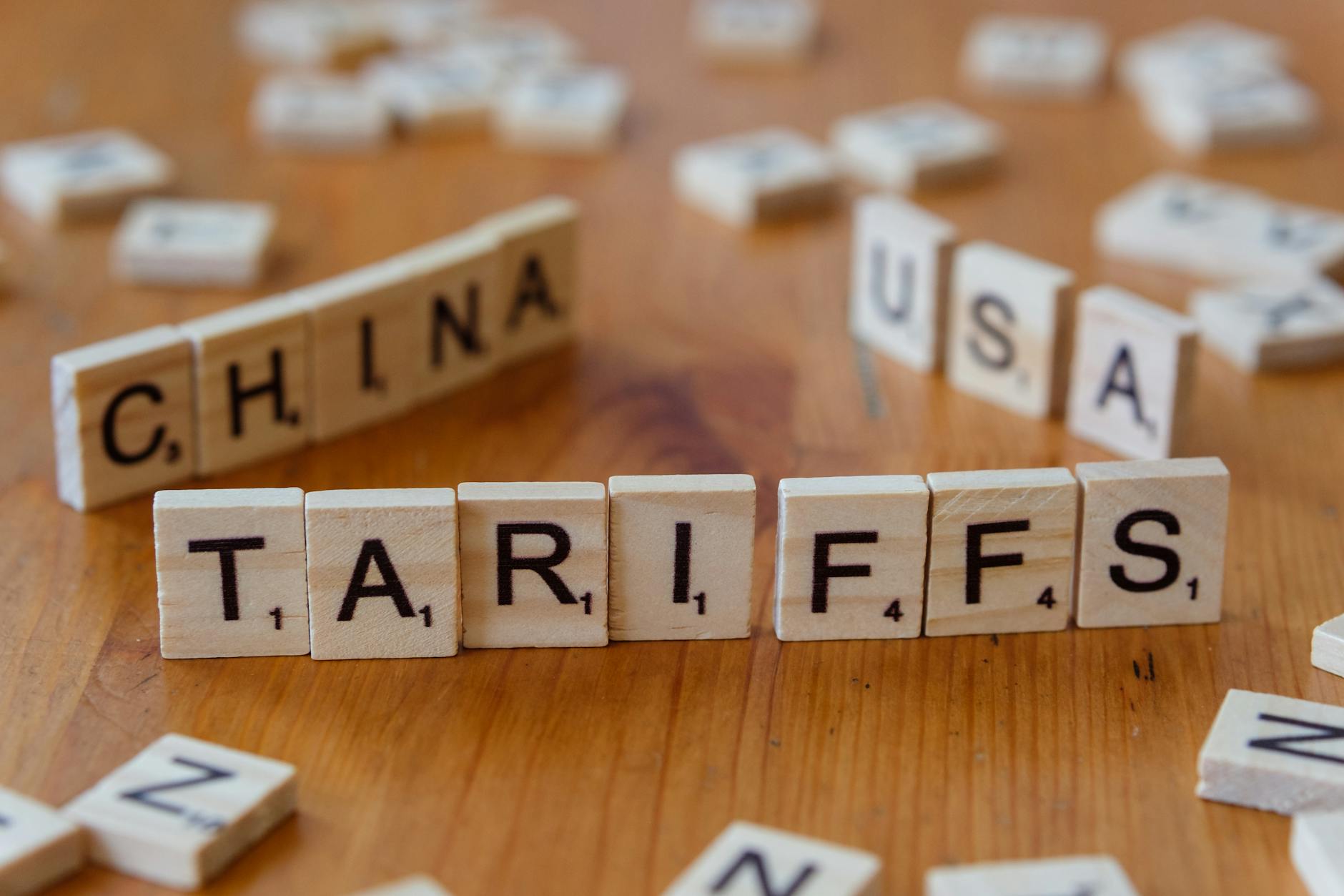 Drewniane klocki z napisami tariffs, China i USA symbolizujące spór handlowy