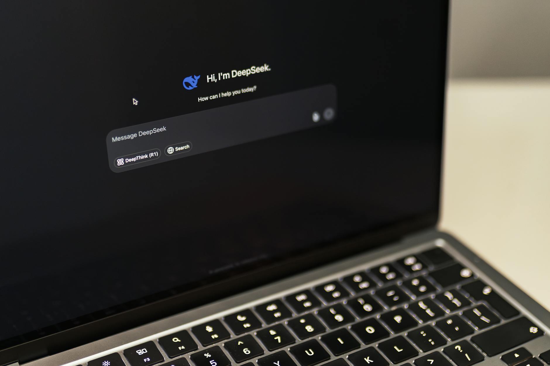 Laptop MacBook z otwartym interfejsem AI DeepSeek na biurku