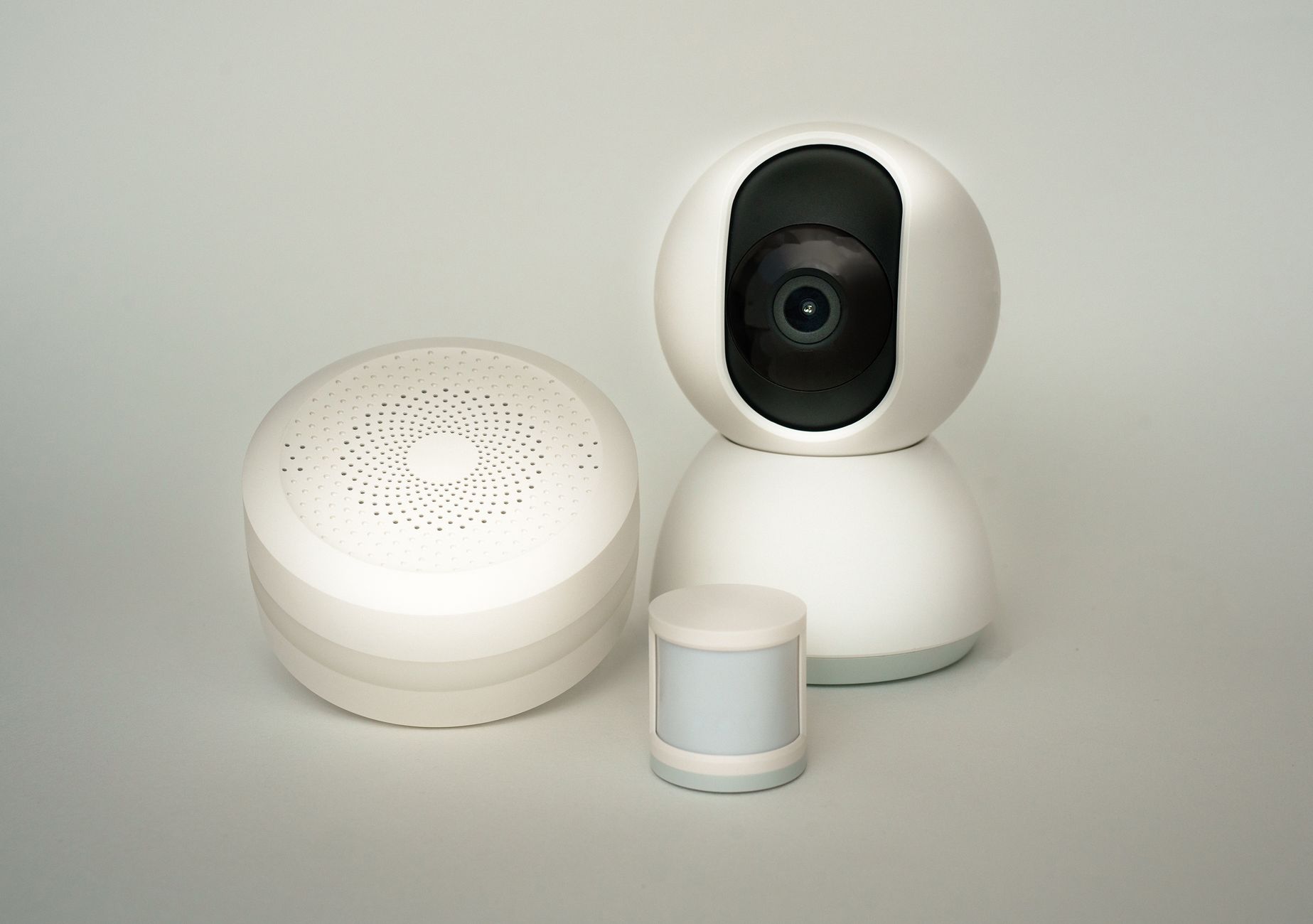 Kamera i czujniki smart home IoT na jasnym, neutralnym tle
