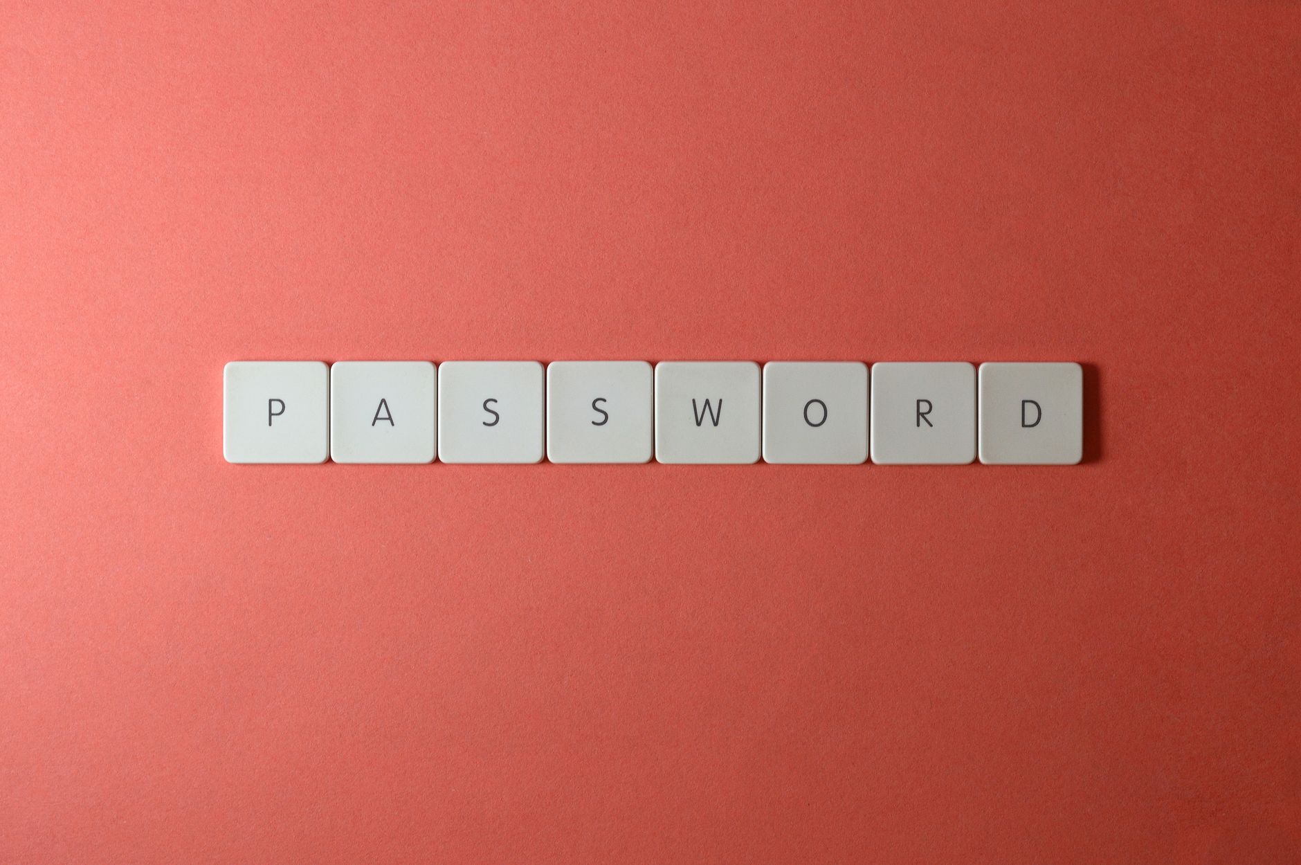 Praktyczny przewodnik po menedżerach haseł dla początkujących Białe klawisze z napisem PASSWORD na koralowym tle