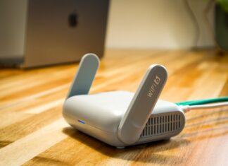 Aktualizacje routera Wi-Fi: jak sprawdzić firmware i nie stracić dostępu do internetu Router Wi‑Fi 6 z antenami i przewodem na drewnianym biurku